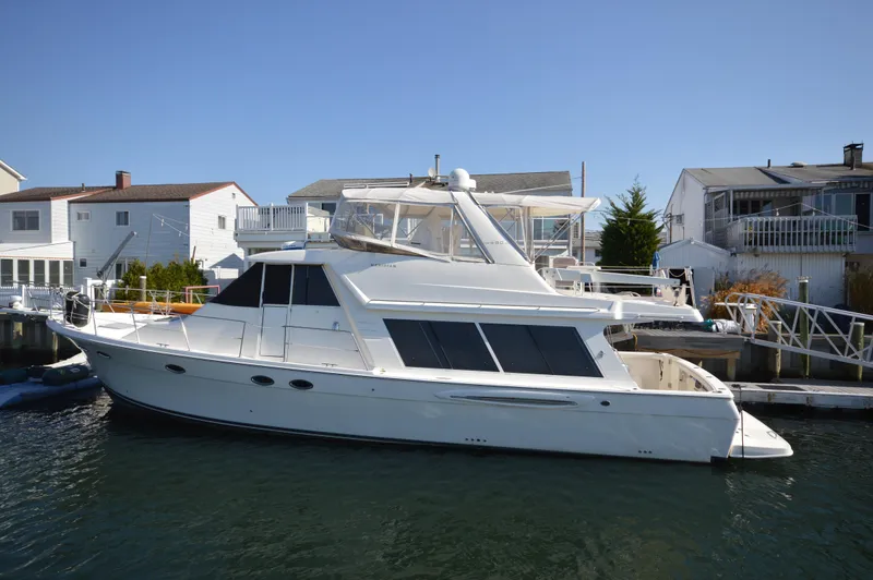 Slide: The Image of 2007 Meridian 490 Pilothouse yacht docked near waterfront homes. - 3