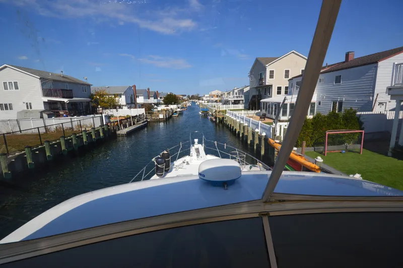 Slide: The Image of View from 2007 Meridian 490 Pilothouse navigating a residential canal under a clear blue sky. - 31