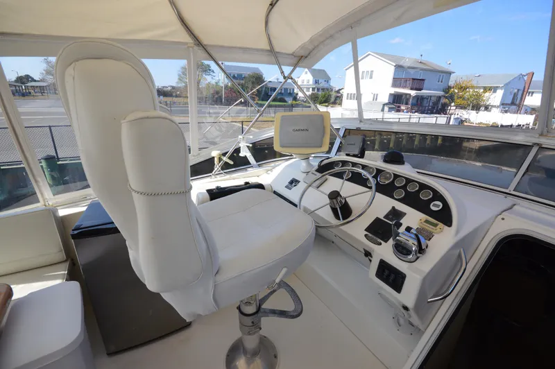 Slide: The Image of 2007 Meridian 490 Pilothouse helm with Garmin navigation, white captain's chair, and control panel. - 38