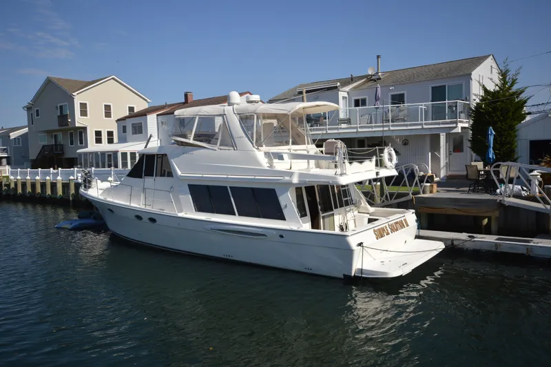 Slide: The Image of 2007 Meridian 490 Pilothouse yacht docked by waterfront homes. - 4