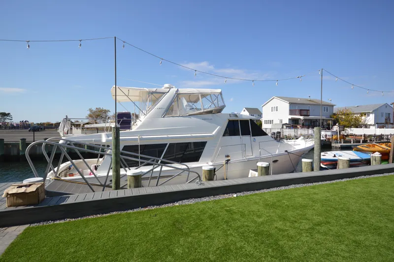 Slide: The Image of 2007 Meridian 490 Pilothouse yacht docked at a marina under clear blue skies. - 5