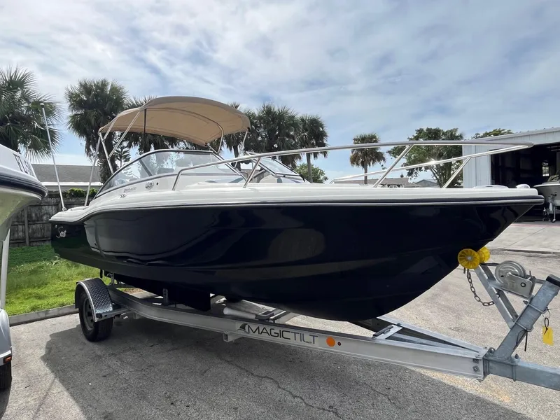 Slide: The Image of 2021 Scout 210 Dorado boat with powerful outboard motor, parked on a trailer. - 4