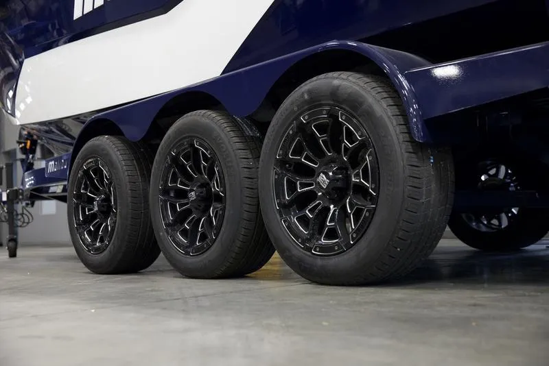 Slide: The Image of 2025 Malibu 25 LSV trailer with triple black alloy wheels in a garage. - 3