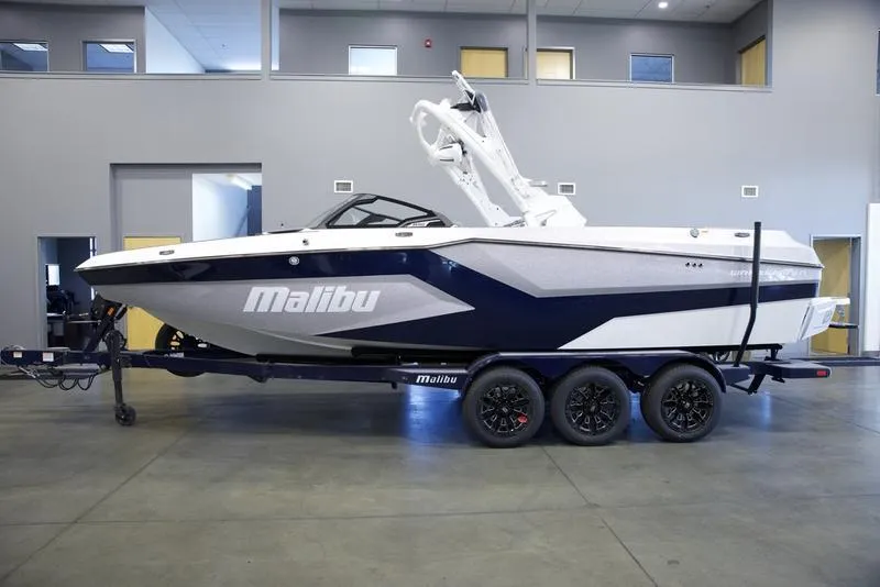 Slide: The Image of 2025 Malibu 24 MXZ boat on trailer in showroom. - 1