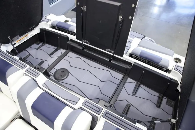Slide: The Image of 2025 Malibu 24 MXZ interior storage compartment with sleek design and cushioned seating. - 2