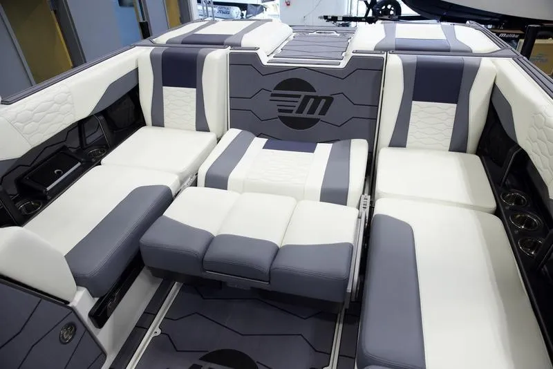 Slide: The Image of 2025 Malibu 24 MXZ boat interior with modern gray and white seating design. - 23