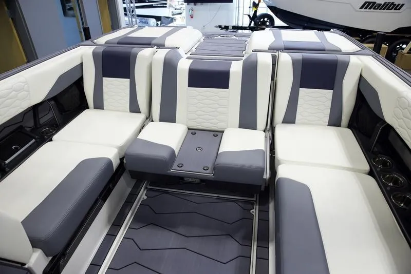 Slide: The Image of 2025 Malibu 24 MXZ interior with luxurious white and gray seating arrangement. - 24
