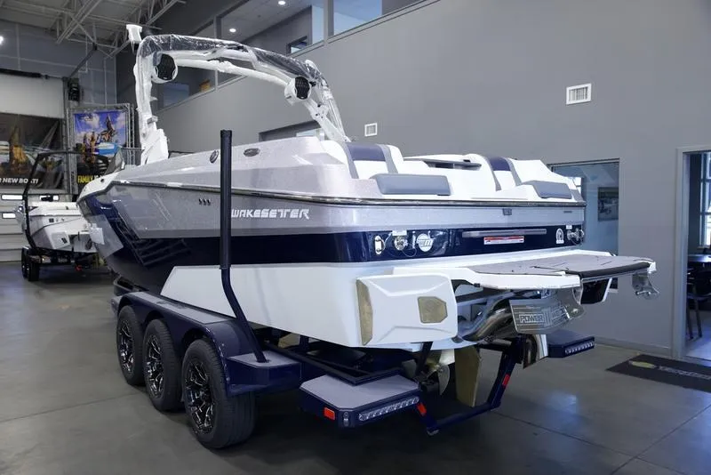 Slide: The Image of 2025 Malibu 24 MXZ boat on trailer in showroom, rear view. - 4