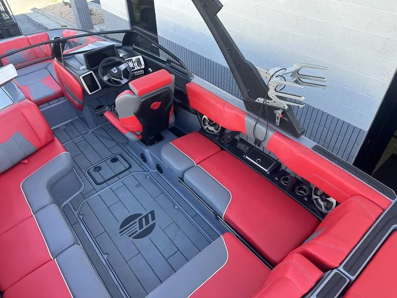 Slide: The Image of 2024 Malibu 23 MXZ boat interior with red and gray seating, modern dashboard, and spacious layout. - 10