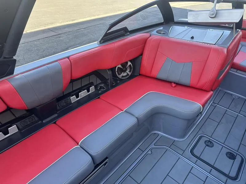 Slide: The Image of 2024 Malibu 23 MXZ boat interior with red and gray seating. - 12