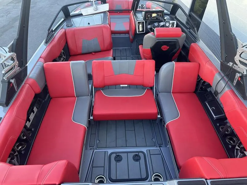 Slide: The Image of 2024 Malibu 23 MXZ boat interior with red and gray seating, modern design. - 21