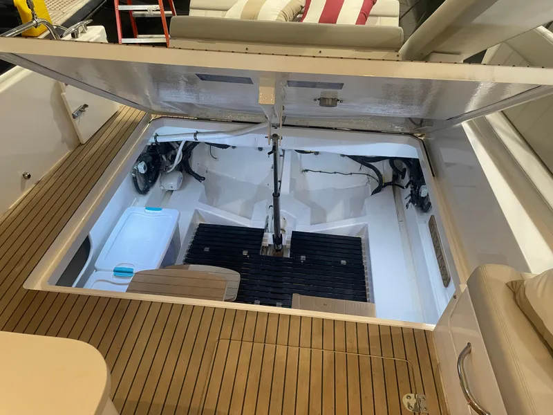 Slide: The Image of 2023 MJM 4 boat engine compartment with open hatch, showcasing interior components and teak flooring. - 12