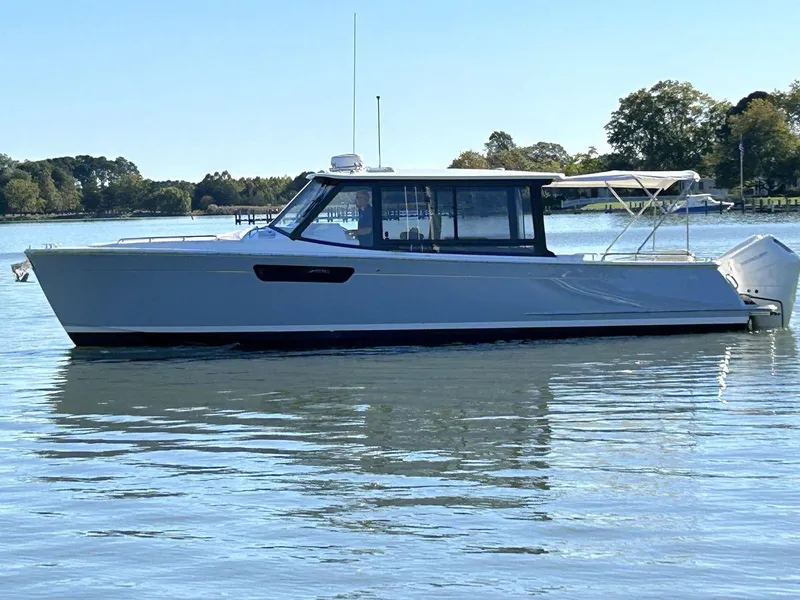 Slide: The Image of 2023 MJM 4 boat on calm water, side view with trees in background. - 3