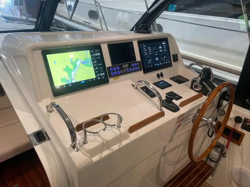 Slide: The Image of 2023 MJM 4 boat helm with navigation screens and wooden steering wheel. - 6
