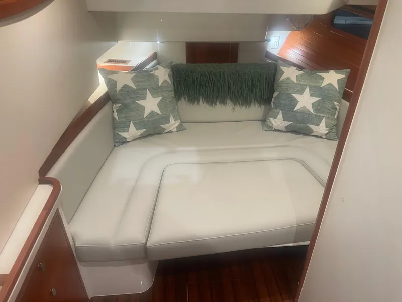 Slide: The Image of 2023 MJM 4 yacht interior with white seating, star-patterned pillows, and wooden accents. - 8