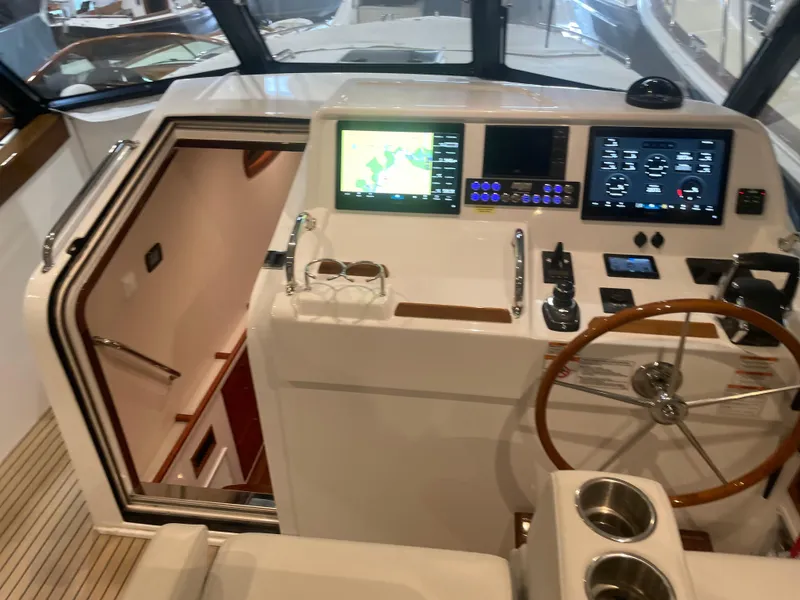 Slide: The Image of Helm of 2023 MJM 4 boat with navigation screens and wooden steering wheel. - 9