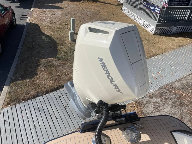 Slide: The Image of 2025 Chris-Craft Launch 28GT with Mercury outboard engine, docked on wooden platform. - 1