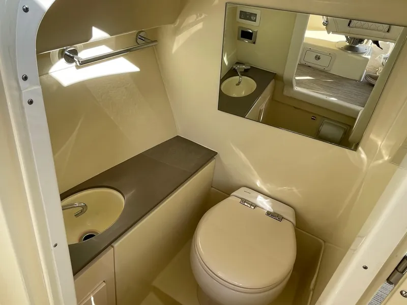 Slide: The Image of 2025 Chris-Craft Launch 28GT boat bathroom with sink, toilet, and mirror. - 18