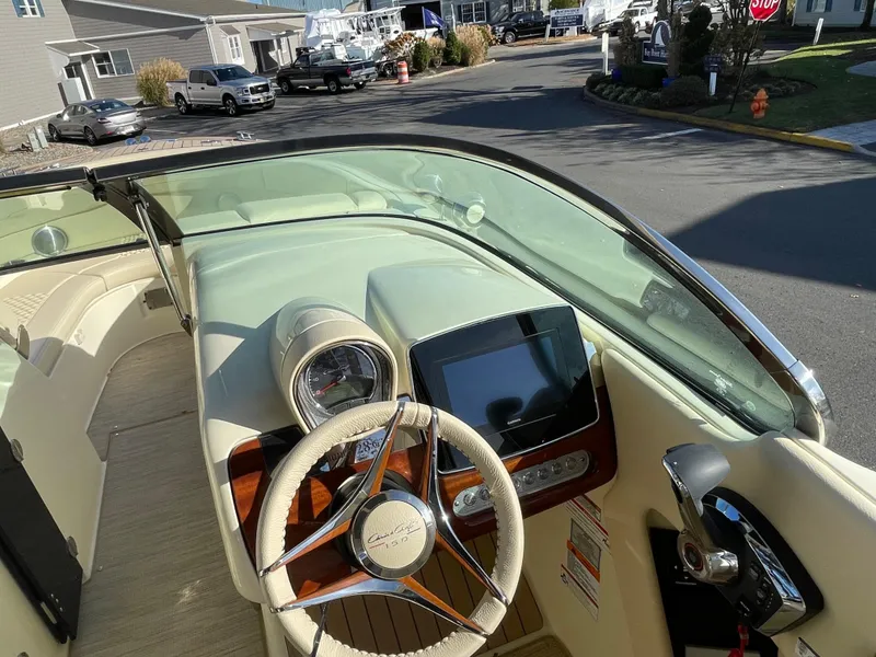 Slide: The Image of 2025 Chris-Craft Launch 28GT boat dashboard with steering wheel and navigation display. - 21