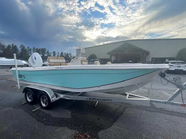 Slide: The Image of 2023 Carolina Skiff 21 Ultra Elite boat on trailer, parked outdoors under cloudy sky. - 3