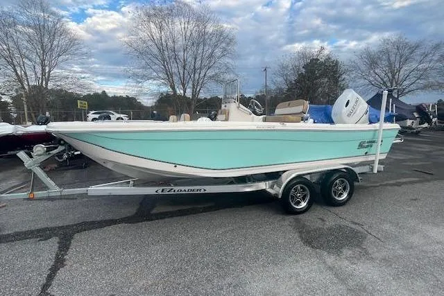 Slide: The Image of 2023 Carolina Skiff 21 Ultra Elite boat on trailer, light blue hull, parked outdoors. - 8