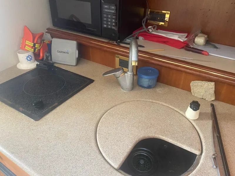 Slide: The Image of 2000 Rampage 30 Offshore boat kitchen with sink, stove, and microwave. - 10
