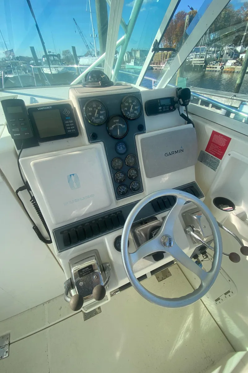 Slide: The Image of 2000 Rampage 30 Offshore boat helm with steering wheel and navigation instruments. - 3