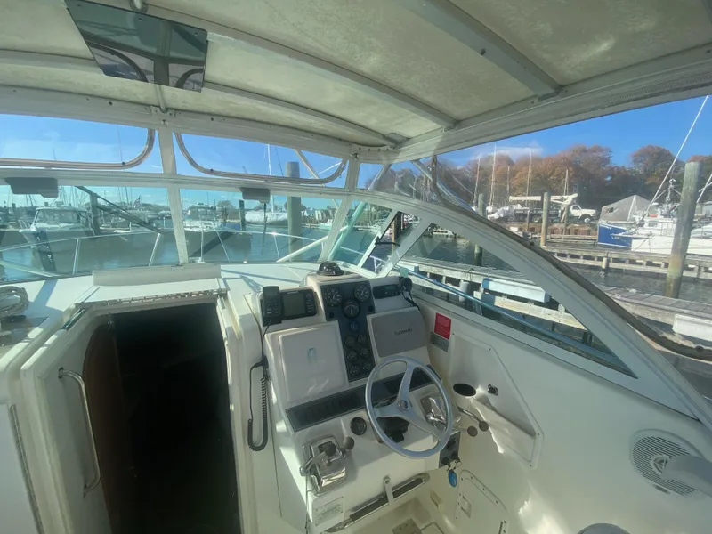 Slide: The Image of 2000 Rampage 30 Offshore boat cockpit with steering wheel and marina view. - 4
