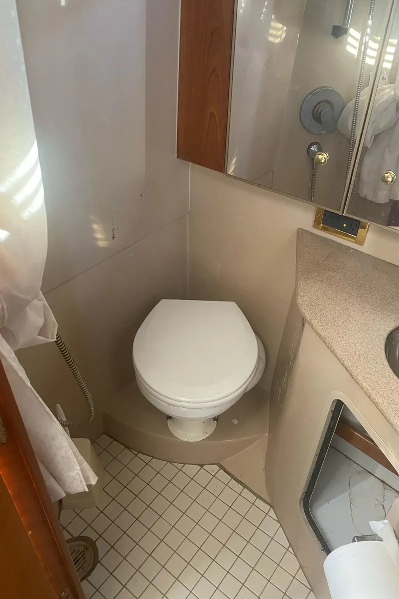 Slide: The Image of 2000 Rampage 30 Offshore boat bathroom with toilet and sink. - 9