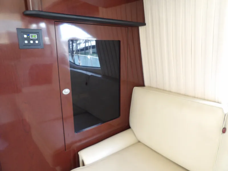 Slide: The Image of Interior of 2008 Sea Ray 44 Sedan Bridge with beige seating and wood paneling. - 23