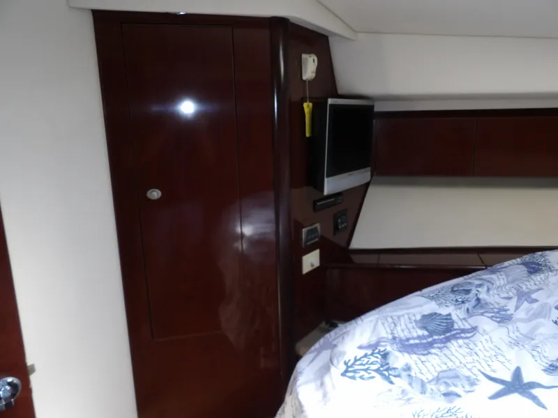 Slide: The Image of Interior of 2008 Sea Ray 44 Sedan Bridge with wood paneling and mounted TV. - 47