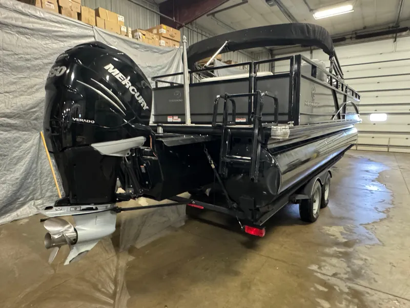 Slide: The Image of 2019 Regency 250 DL3 pontoon boat with Mercury outboard in a storage facility. - 3