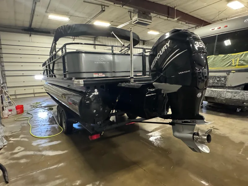 Slide: The Image of 2019 Regency 250 DL3 pontoon boat with Mercury 350 engine in a garage setting. - 4