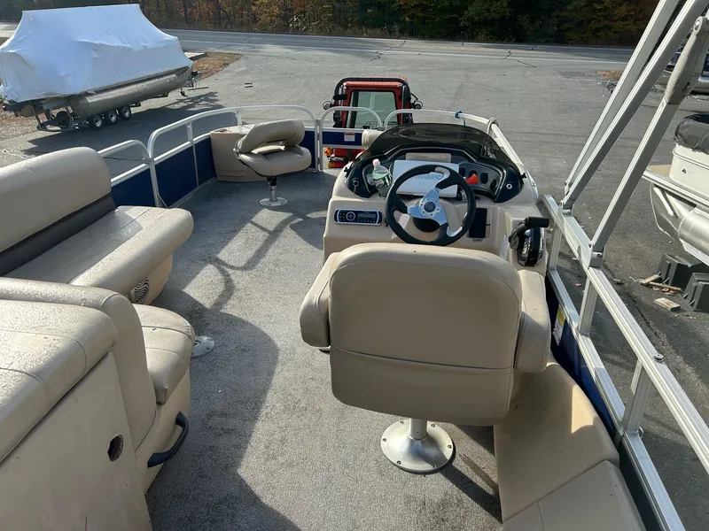 Slide: The Image of 2017 Sun Tracker Fish Barge 22 DLC interior with beige seating and steering console. - 2