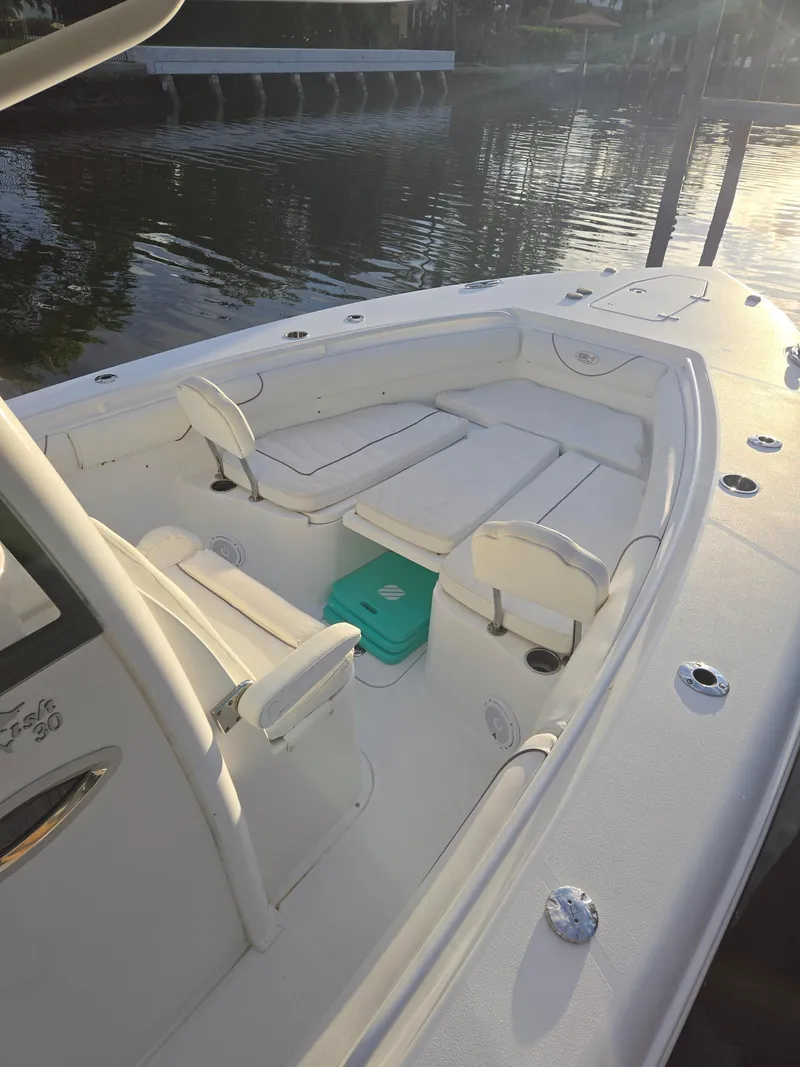 Slide: The Image of 2018 Sea Hunt Gamefish 30 boat with forward seating, docked by calm waters. - 3
