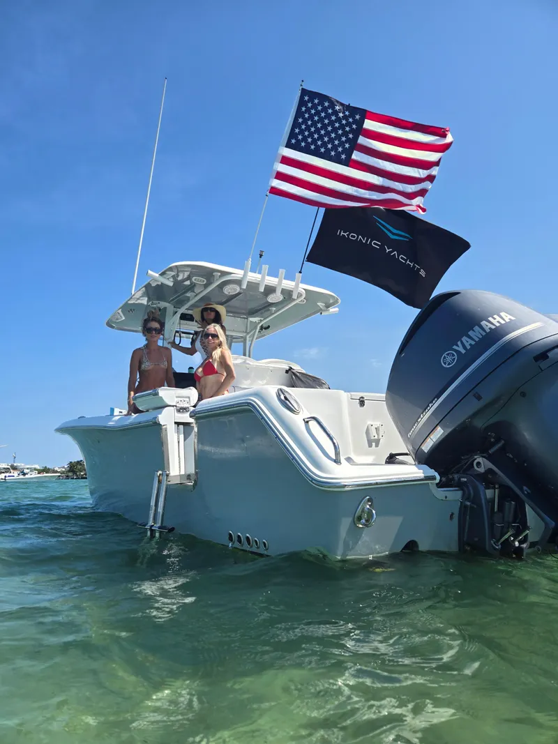 Slide: The Image of 2018 Sea Hunt Gamefish 30 with flags, anchored in clear water. - 9