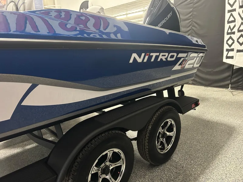 Slide: The Image of 2025 Nitro ZV20 boat on trailer, blue and white design, displayed indoors. - 13