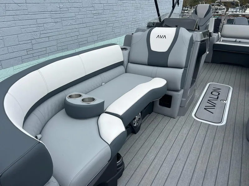 Slide: The Image of 2025 Avalon 2385 Catalina VRB boat interior with gray and white seating, cup holders, and logo mat. - 7