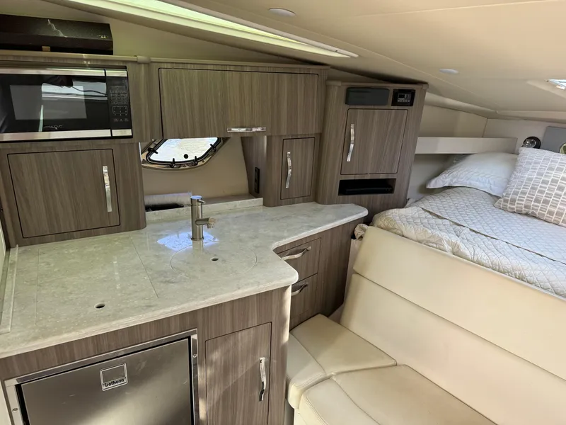 Slide: The Image of 2020 Regal 35 Sport Coupe interior with kitchenette and bed, featuring modern cabinetry and appliances. - 16