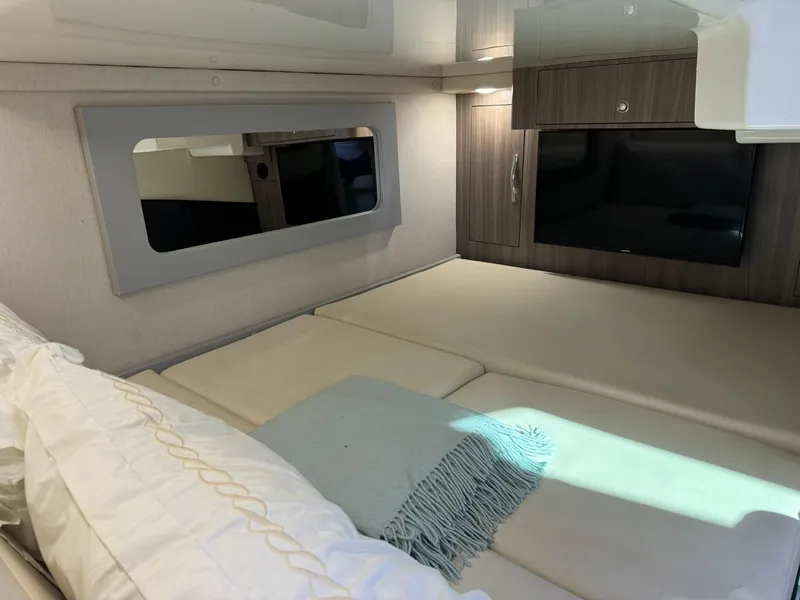Slide: The Image of Interior cabin of 2020 Regal 35 Sport Coupe with bed, TV, and wood cabinetry. - 21
