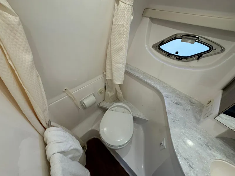 Slide: The Image of 2020 Regal 35 Sport Coupe bathroom with toilet, countertop, and porthole window. - 26