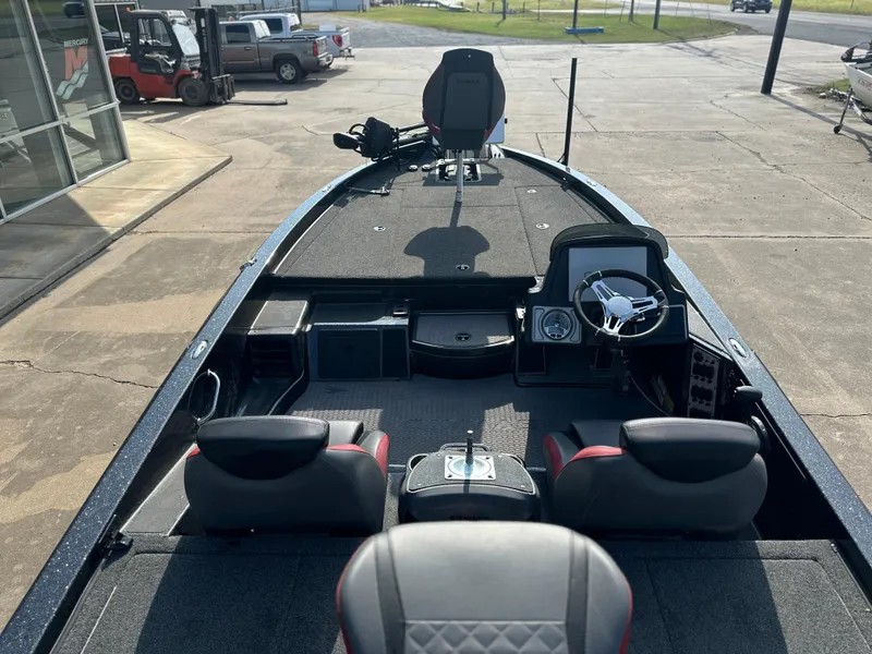 Slide: The Image of 2022 Caymas CX19 boat interior with seating and steering wheel, parked outdoors. - 4