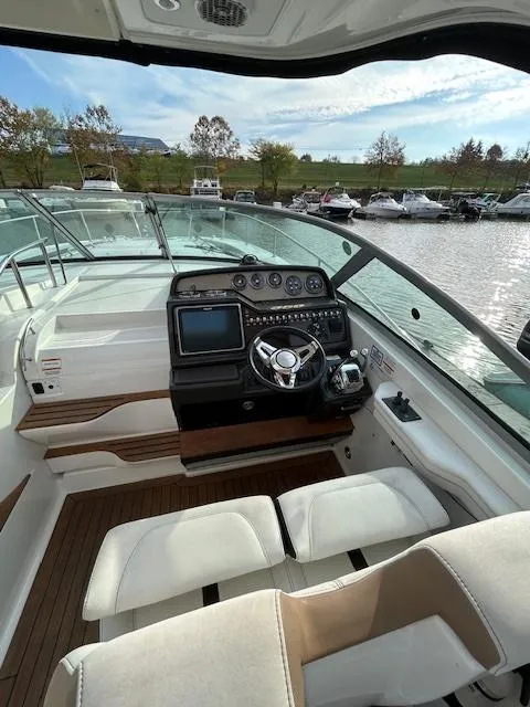 Slide: The Image of 2016 Sea Ray 350 Sundancer helm with modern controls and waterfront view. - 11