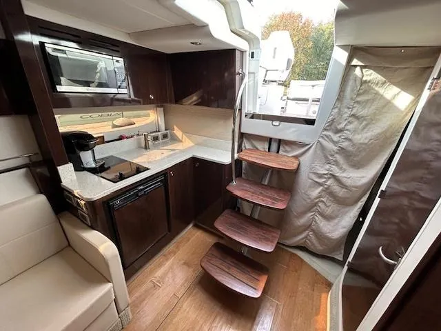 Slide: The Image of Interior of 2016 Sea Ray 350 Sundancer yacht with modern kitchen and wooden stairs. - 17