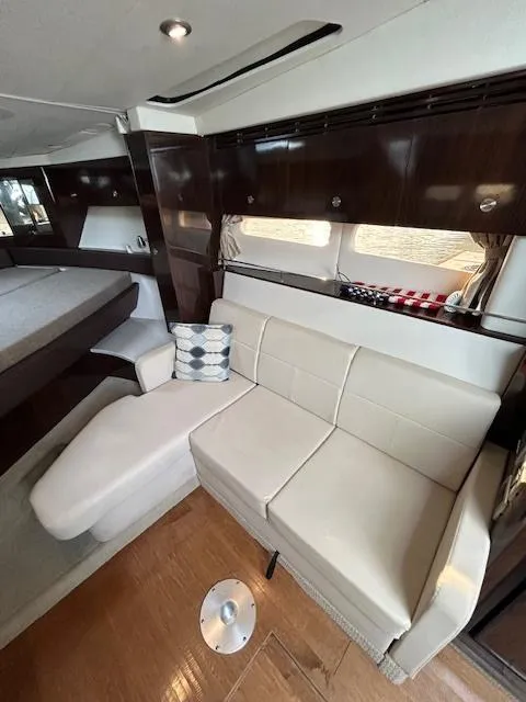Slide: The Image of Interior of 2016 Sea Ray 350 Sundancer with modern seating and wood accents. - 19