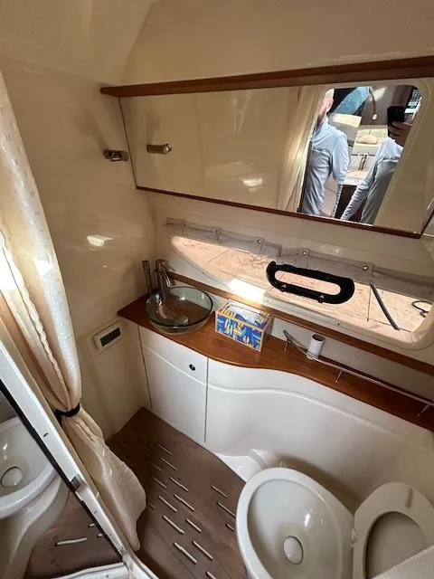 Slide: The Image of 2016 Sea Ray 350 Sundancer bathroom with modern fixtures and wood accents. - 24