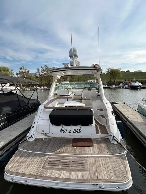 Slide: The Image of 2016 Sea Ray 350 Sundancer docked, rear view, with "Not 2 Bad" on the stern. - 3