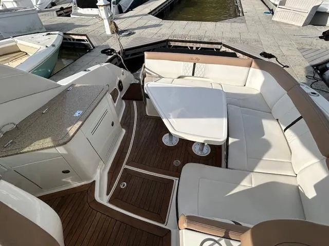 Slide: The Image of 2016 Sea Ray 350 Sundancer boat interior with seating and table, docked at marina. - 6