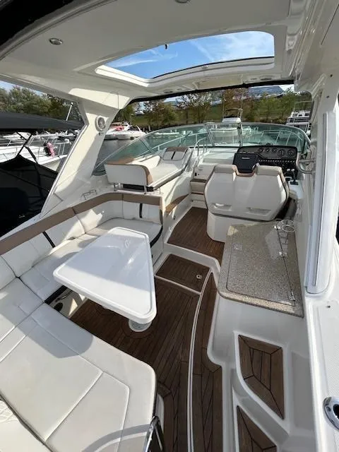 Slide: The Image of 2016 Sea Ray 350 Sundancer interior with seating, table, and helm. - 7