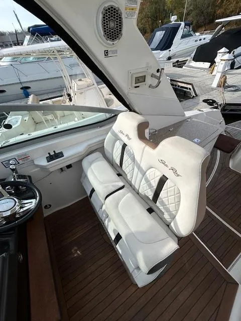 Slide: The Image of 2016 Sea Ray 350 Sundancer interior with white seating and wood flooring. - 9